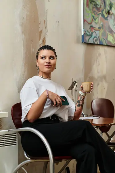 A young woman with a unique style savors her drink while seated in a cozy cafe setting. — Stock Photo