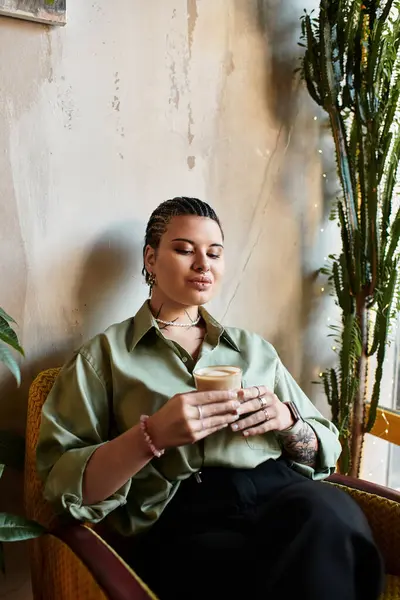 Mulher desfrutando de café em um café acolhedor, cercado por vegetação e luz quente. — Fotografia de Stock