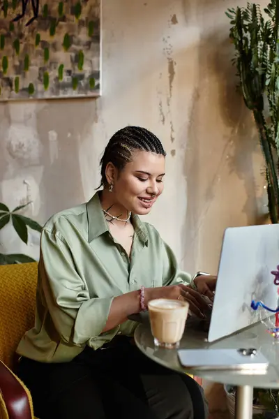 A young woman smiles while working at a charming cafe and enjoying her drink. — Stock Photo