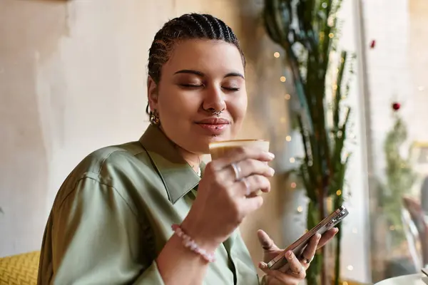 A young woman enjoys her coffee while relaxing in a cozy cafe, radiating warmth and charm. — Stock Photo