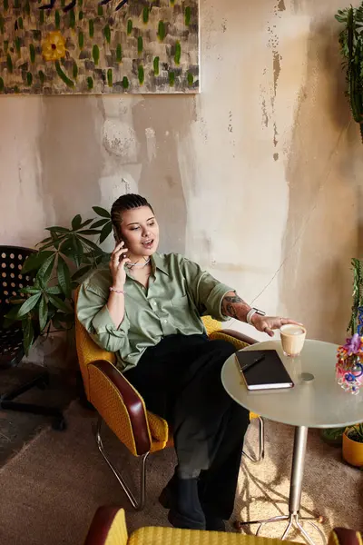 A young woman engages in a lively phone call at a vibrant cafe, radiating joy. — Stock Photo