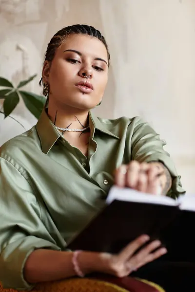 In a charming cafe, a young woman with braided hair immerses herself in a book, exuding confidence. — Stock Photo