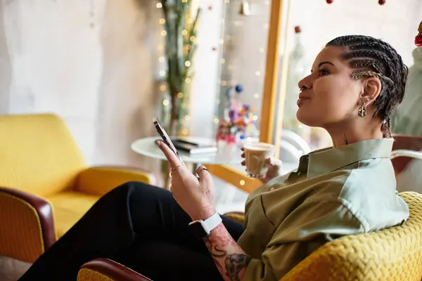 A young woman enjoys coffee while scrolling on her phone in a charming cafe. — Stock Photo