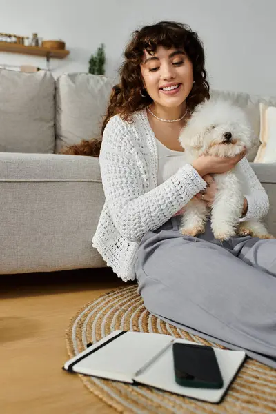 Woman relaxes on a soft rug while holding her adorable dog during a calm afternoon at home — Stock Photo