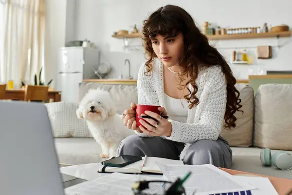 Cozy afternoon spent with a warm drink while studying at home, accompanied by a playful dog. — Stock Photo
