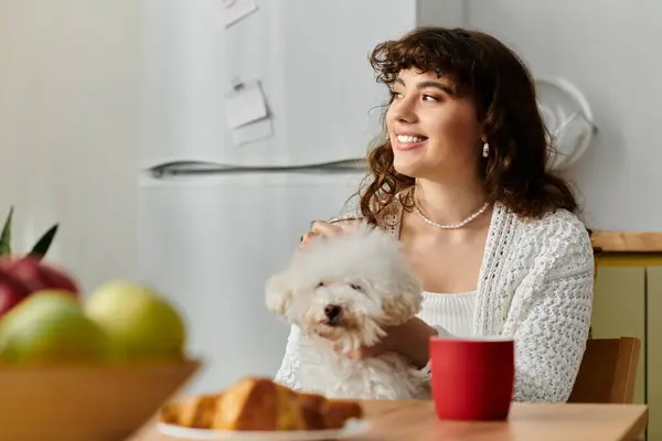Bright morning filled with warmth as a young woman smiles while cuddling her dog at the table. — Stock Photo