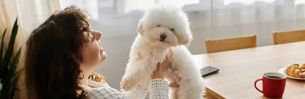 Bright morning light fills the room as a woman cuddles her dog, surrounded by breakfast treats. — Stock Photo
