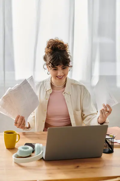 Brightly lit space features a young woman happily organizing her documents while working. — Stock Photo
