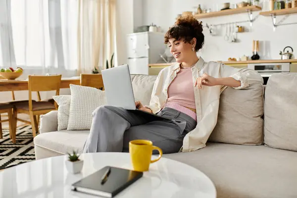Engaged in her work, the young woman smiles brightly while typing on her laptop. — Stock Photo