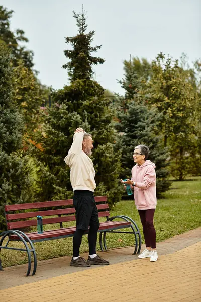 Um casal amoroso compartilha uma conversa alegre em um belo parque cercado por árvores. — Fotografia de Stock