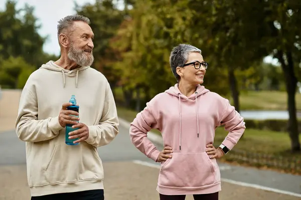 Loving seniors share laughter and good company while strolling together in a beautiful park. — Stock Photo