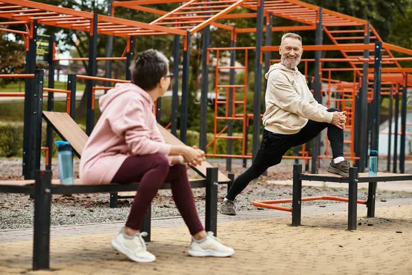 A happy couple enjoys outdoor quality time with light exercise and stretching. — Stock Photo