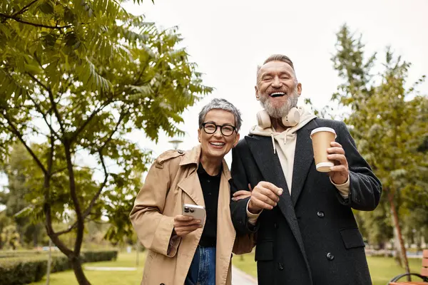A loving couple strolls through a lush park, sharing laughter and enjoying a joyful moment together. — Stock Photo