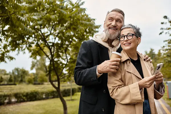 Amando idosos saboreando uns aos outros companhia enquanto sorvendo café em meio a belas árvores. — Fotografia de Stock