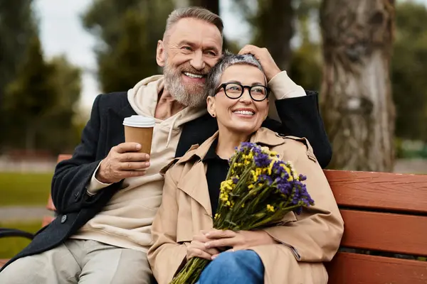 A loving couple shares a tender moment on a bench, radiating happiness in nature. — Stock Photo