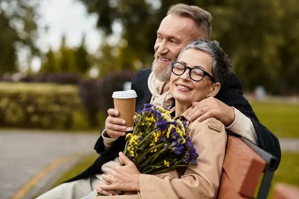 Ein reifes Paar teilt einen freudigen Moment im Park, umgeben von Natur, Blumen und Liebe. — Stockfoto