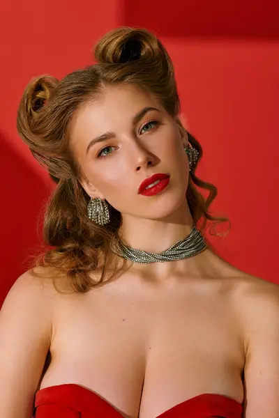 L'elegante giovane donna posa fiduciosa in un audace vestito rosso con accessori scintillanti. — Foto stock