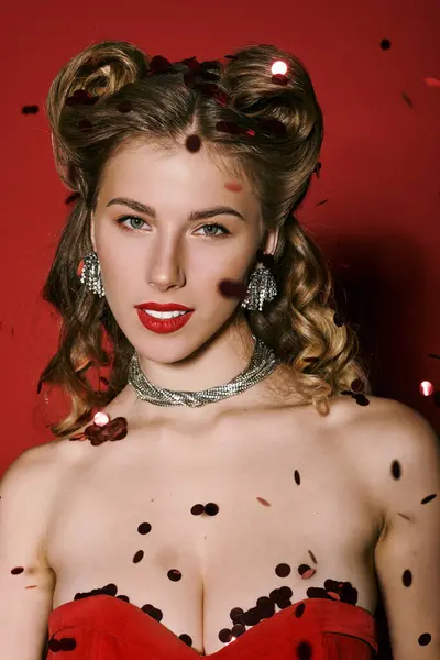 Uma jovem mulher elegante encanta em traje elegante, cercada por confetes cintilantes. — Fotografia de Stock