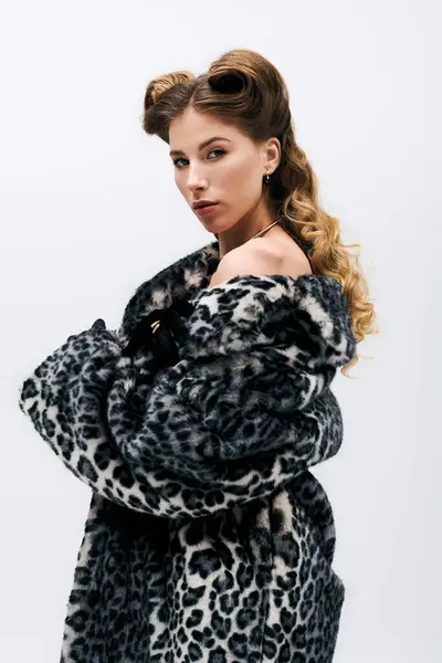 Appealing young woman poses confidently in leopard print coat, exuding chic fashion and allure. — Stock Photo