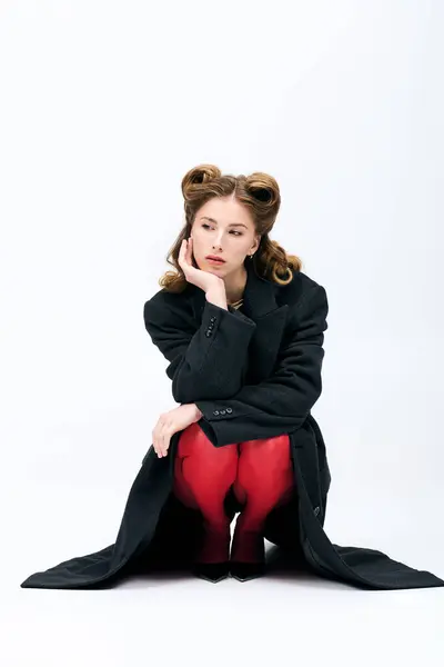 Uma jovem mulher elegante senta-se graciosamente, destacando seu senso de moda. — Fotografia de Stock