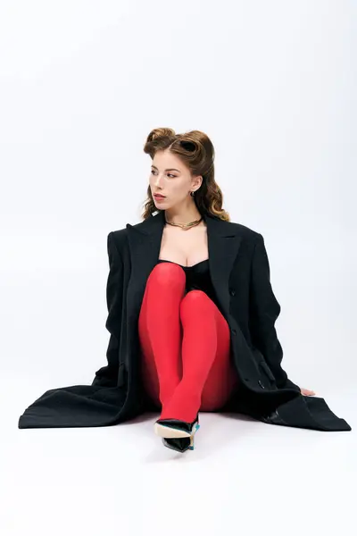 Uma jovem mulher chique usa meias vermelhas impressionantes em um estúdio elegante. — Fotografia de Stock