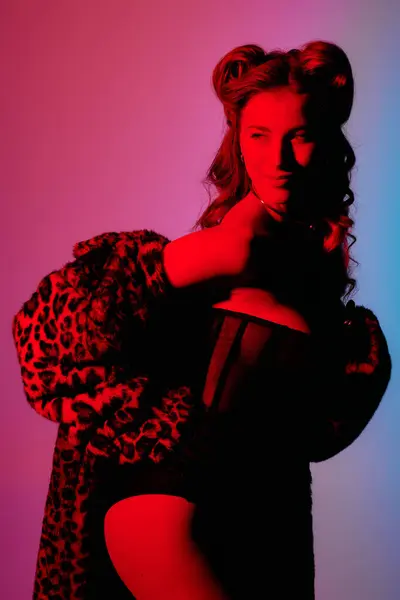 Uma jovem exala confiança em uma roupa chique, iluminada por luzes vibrantes e coloridas. — Fotografia de Stock