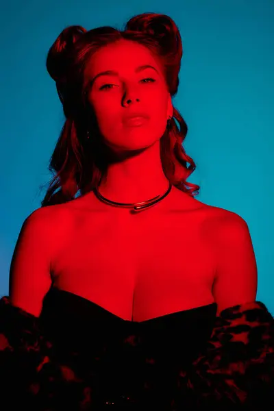 Jovem mostra moda moda com um penteado marcante em iluminação vívida durante a noite. — Fotografia de Stock
