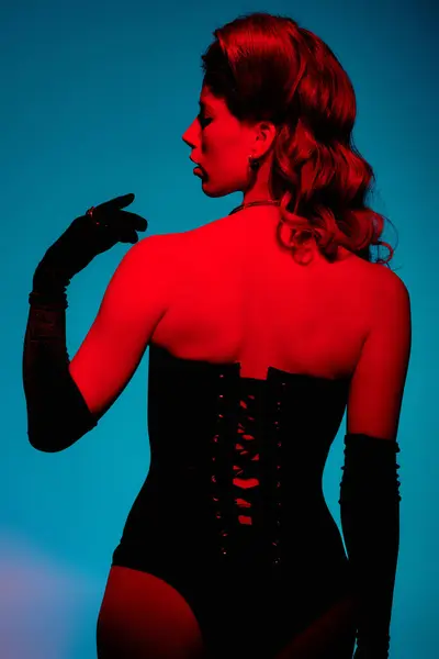 Una giovane donna sicura di sé mette in mostra il suo vestito chic con luci e colori audaci. — Foto stock