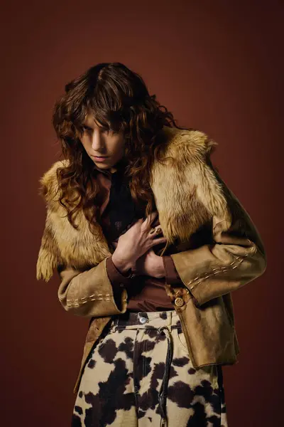 Un giovane uomo con i capelli ricci posa pensieroso in un abito vintage in un ambiente caldo. — Foto stock