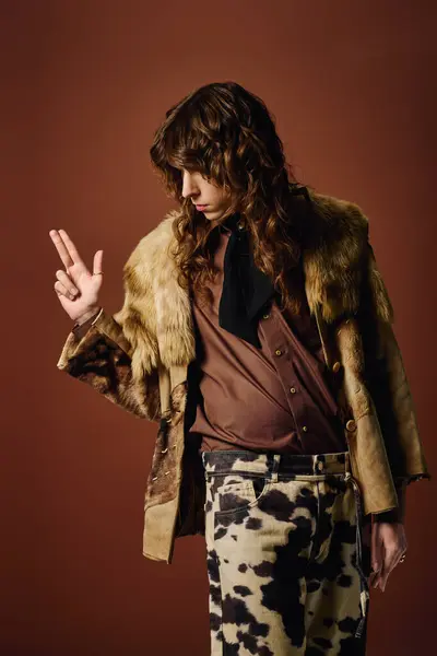A stylish young man confidently poses in a fur coat, showcasing his unique flair. — Stock Photo