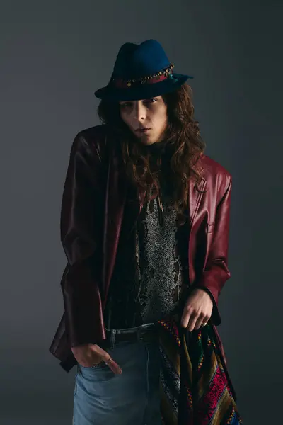 Un bel homme aux cheveux bouclés modèle une tenue tendance dans un espace studio artistique, exprimant le style. — Stock Photo