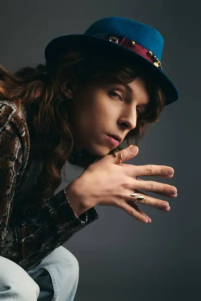 A young, handsome man poses with an artistic expression, highlighting his unique fashion choices. — Stock Photo
