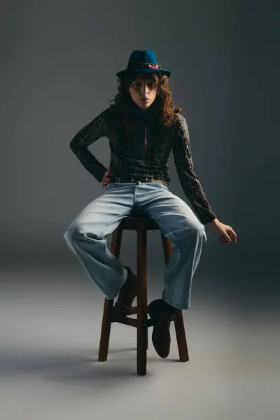 A stylish man exudes confidence while sitting on a stool, showcasing modern fashion. — Stock Photo