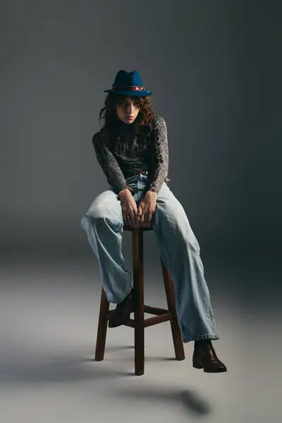 A handsome man in casual attire poses confidently on a stool, showcasing unique fashion choices. — Stock Photo