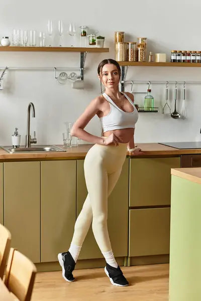 A young woman enjoys moving to the music, dancing in a stylish kitchen setting. — Stock Photo