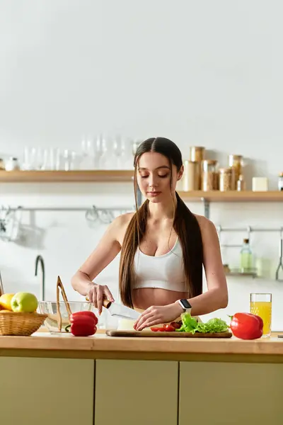 Apto mulher habilmente fatias vegetais frescos para criar uma deliciosa salada em sua cozinha moderna. — Fotografia de Stock