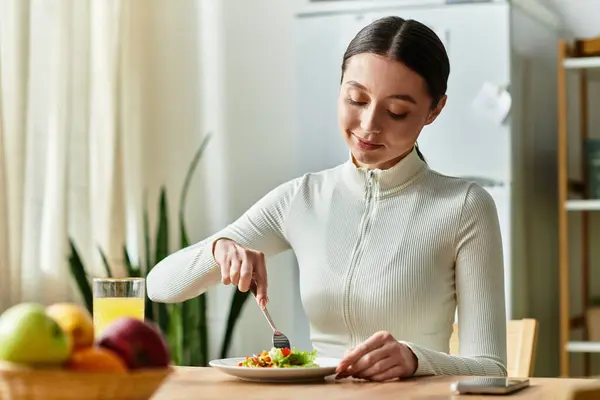 A young woman is savoring a nutritious breakfast with vibrant vegetables in a cozy kitchen. — Stock Photo