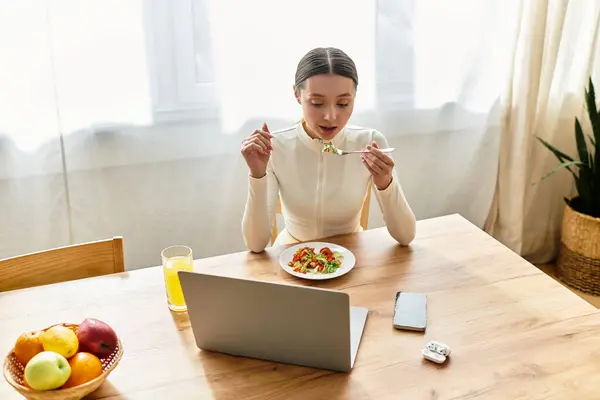 Young woman indulges in a nutritious meal, savoring every bite in a cozy kitchen setting. — Stock Photo