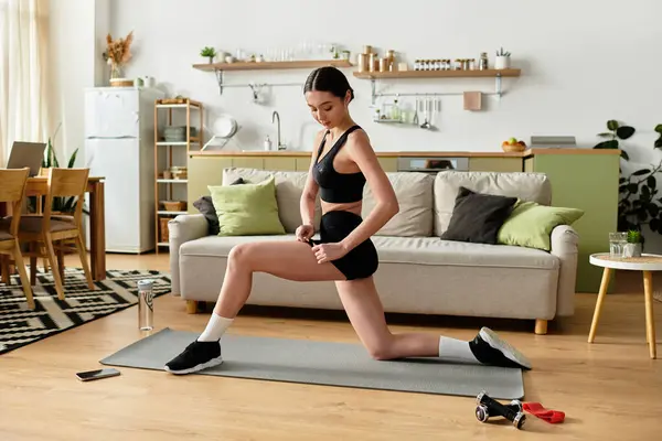 Jovem mulher no elegante sportswear preto executa lunges em um espaço de apartamento moderno. — Fotografia de Stock