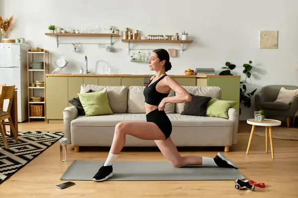 Uma jovem mulher de sportswear preto executa lunges em seu elegante apartamento durante uma sessão de fitness. — Fotografia de Stock