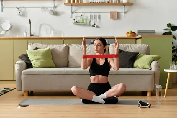 A beautiful young woman in black sportswear is practicing exercise in her stylish apartment. — Stock Photo