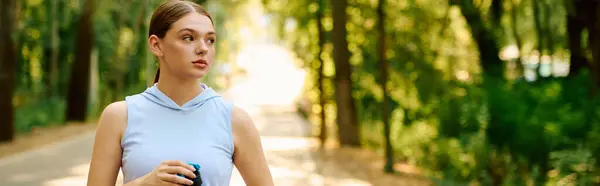 Athletic woman jogs on a peaceful trail, savoring natures beauty and sunlight. — Stock Photo