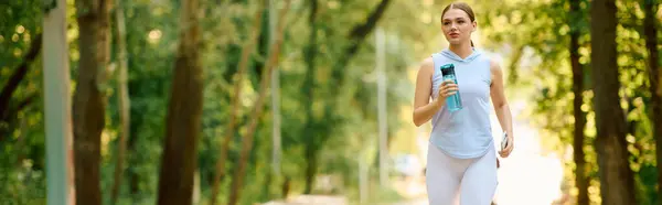 A young athletic woman enjoys a refreshing jog on a sunny morning amidst vibrant greenery. — Stock Photo