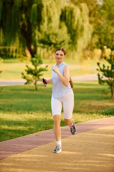 Una giovane e bella atleta si esibisce con gioia lungo un percorso panoramico immersa nel verde. — Foto stock