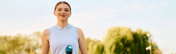 Una bella donna atletica si distingue all'aperto con un sorriso, pronta per la sua routine di allenamento all'aperto. — Foto stock