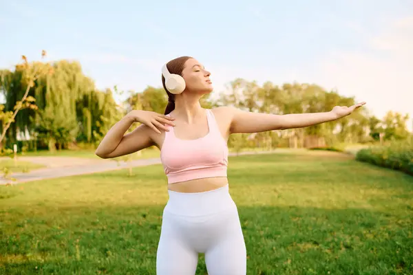 A young athlete embraces the joy of exercise while wearing headphones and dancing outdoors. — Stock Photo