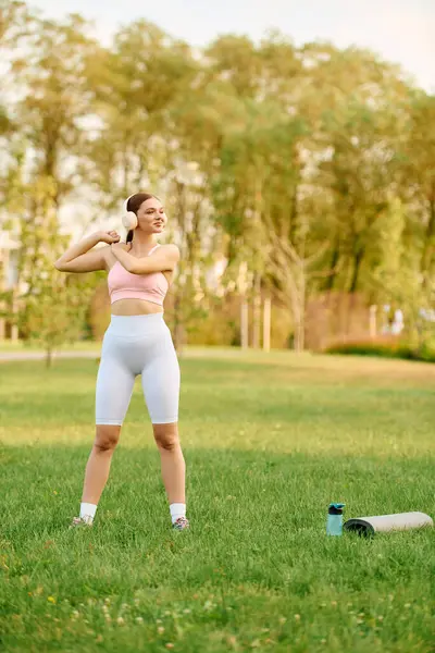 A young athletic woman stretches happily under the warm sun, surrounded by natures beauty. — Stock Photo