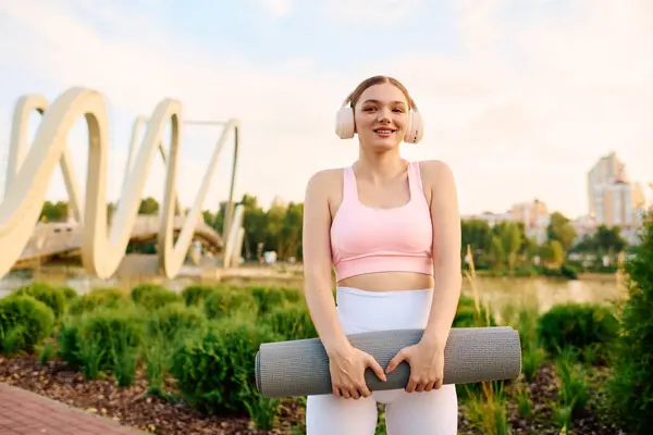 Cheerful beautiful woman engages in yoga by the riverside, embracing serenity and nature. — Stock Photo