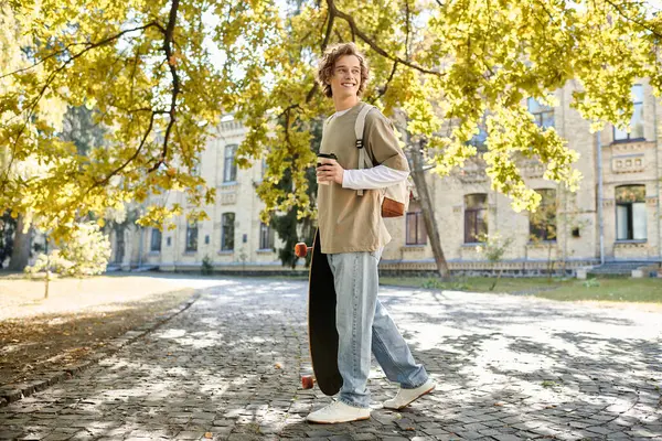 Яркий солнечный свет проникает сквозь деревья, как модный молодой человек скейтборды, держа чашку. — стоковое фото