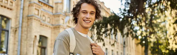 Young man exudes confidence as he strolls through a university campus bathed in sunlight — Stock Photo